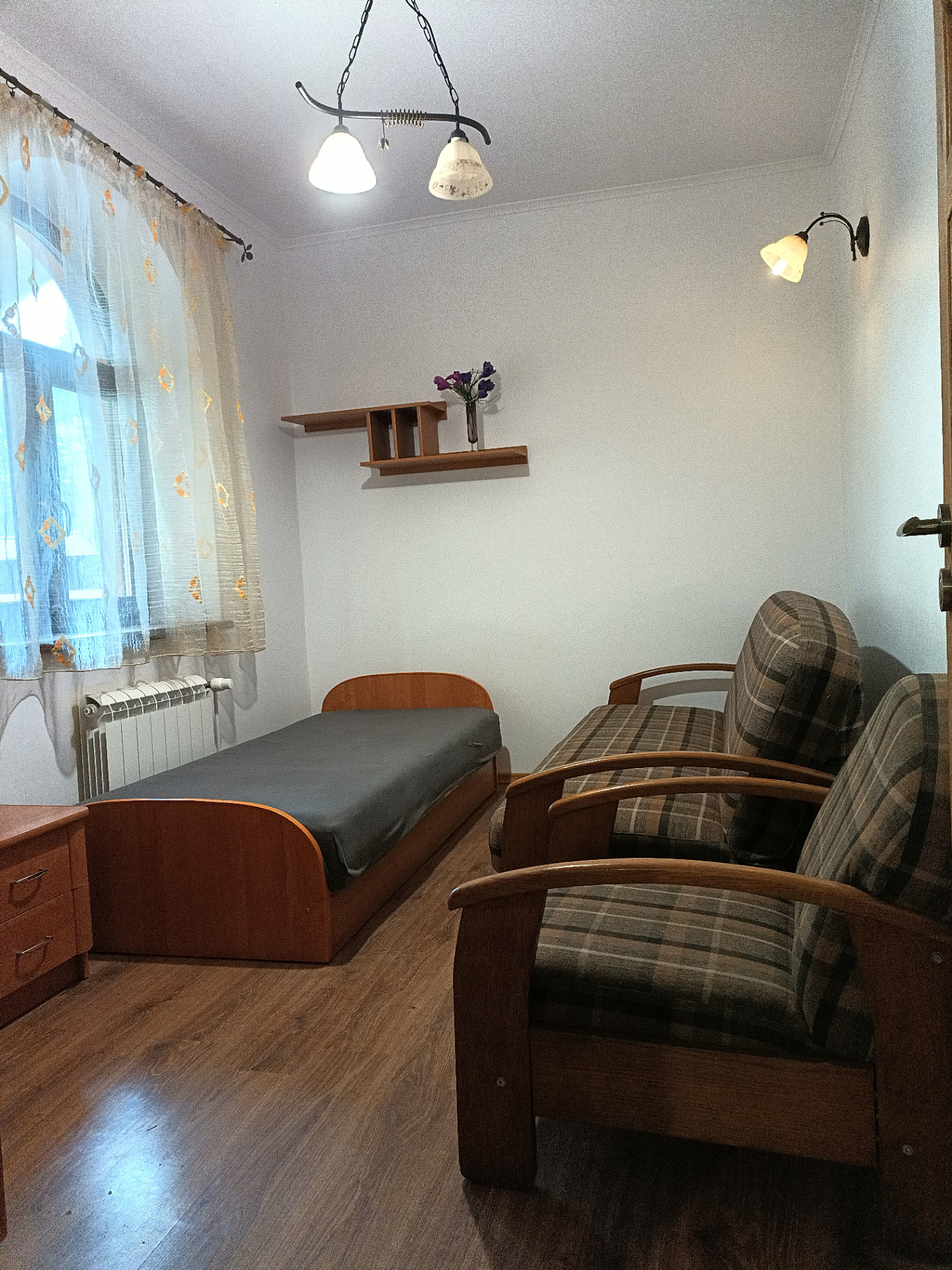 Domek 9 — sypialnia z łóżkiem i fotelami